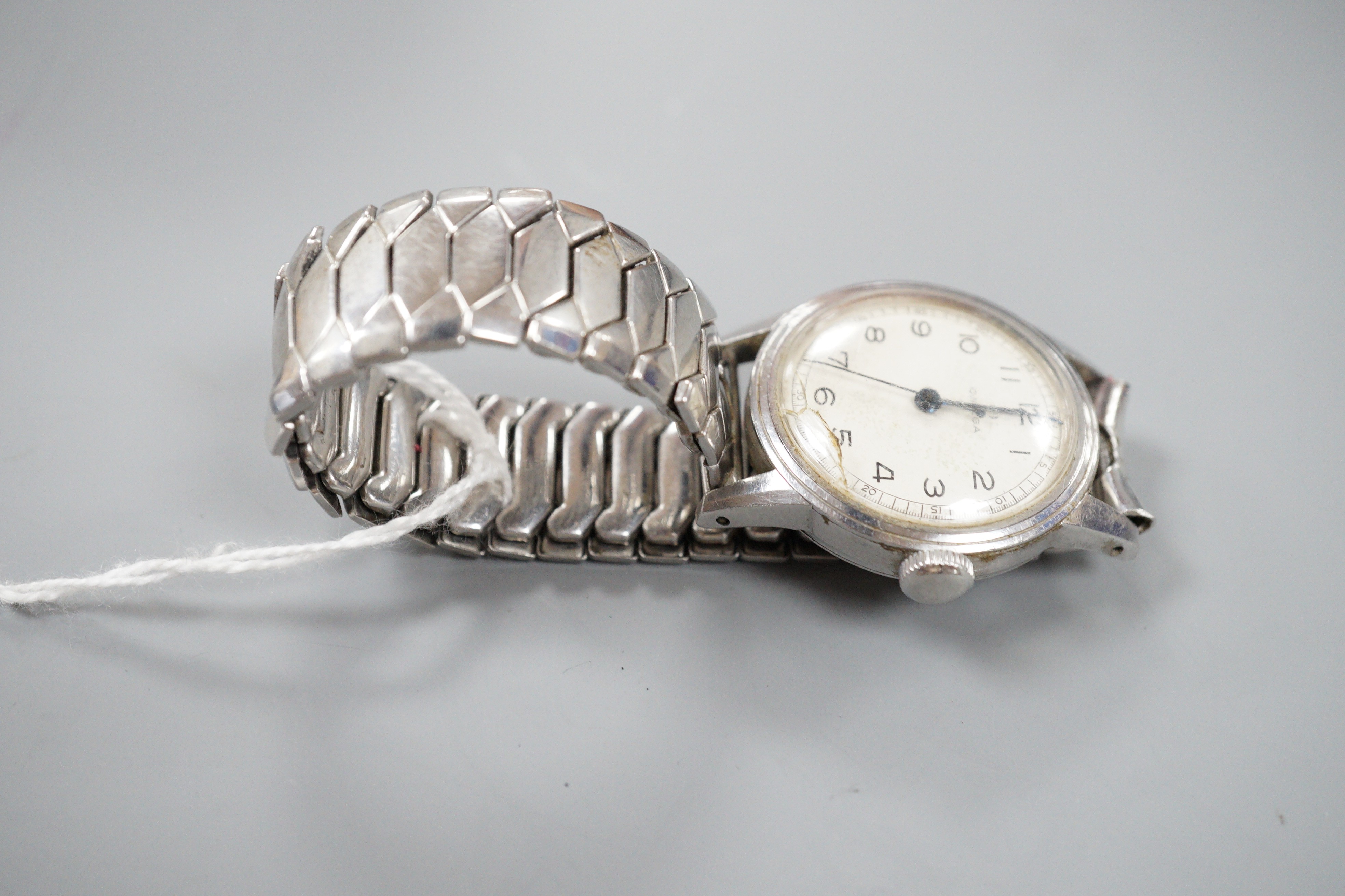 A gentleman's early 1940's mid size stainless steel Omega manual wind wrist watch, with Arabic dial, case diameter 31mm, on associated flexible bracelet, no box or papers (dial cover cracked).